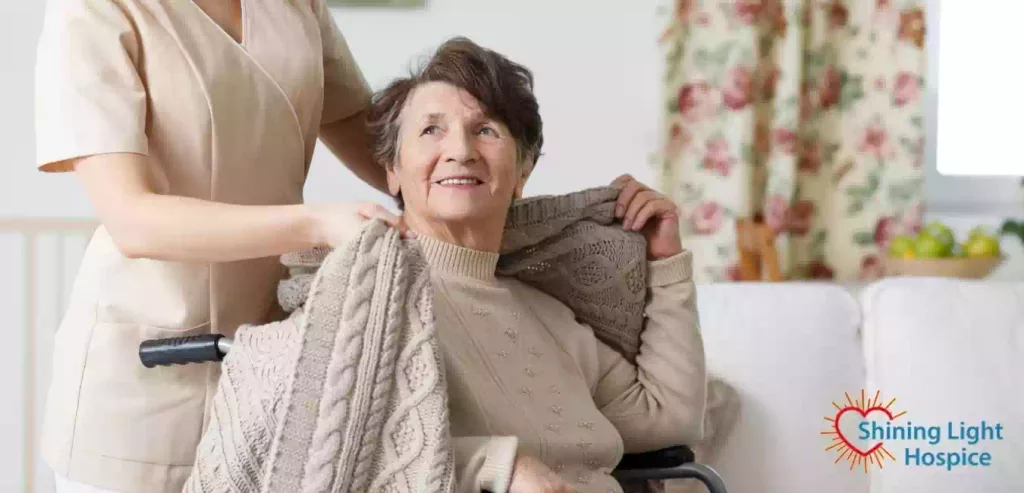 Caregiver covering senior woman with a blanket